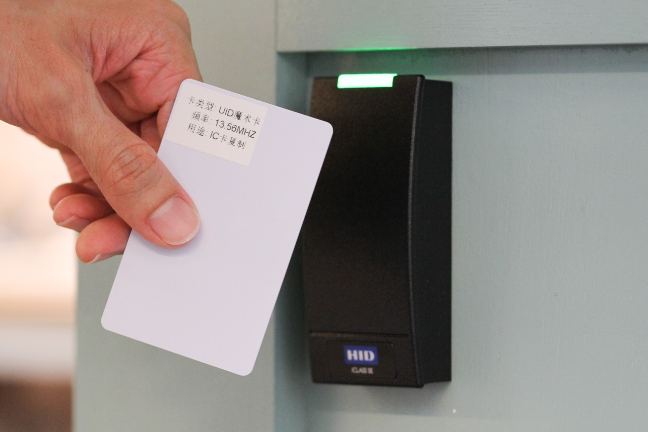 a labeled UID 'magic card' held in front of a HID iClass door reader, which turned green to indicate 'access granted'