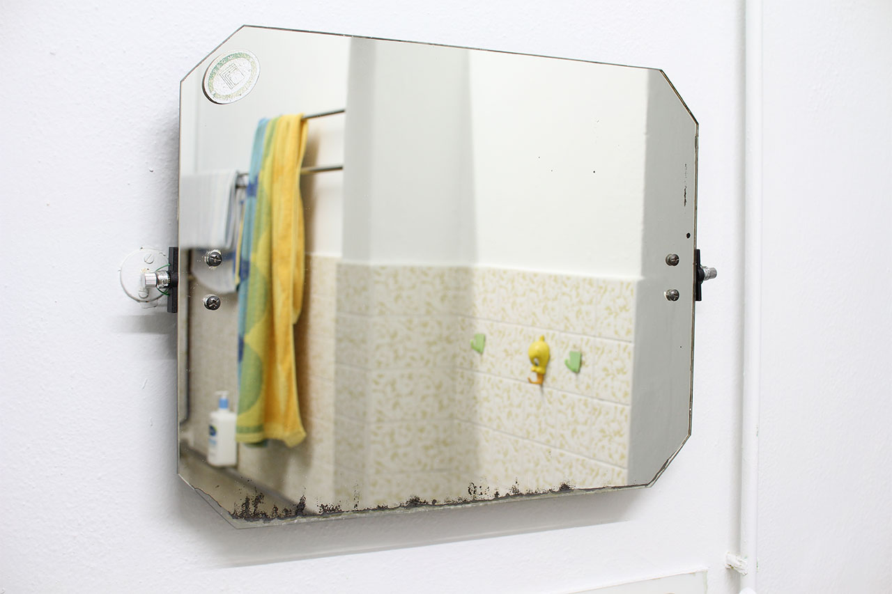 photo of the same wall prior, now with the tilting mirror re-attached